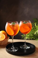 Refreshing spritzer cocktail with mint and oranges on wooden table