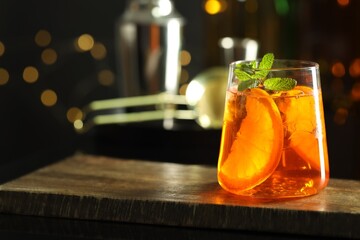 Refreshing spritzer cocktail on wooden table in bar, closeup. Space for text