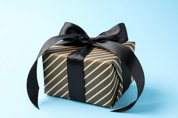 Beautiful wrapped gift on light blue background, closeup