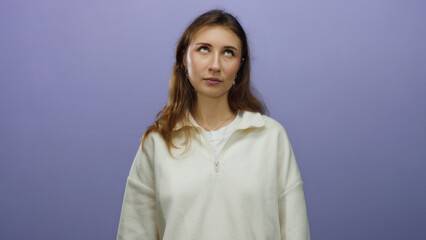 Obraz premium Woman expressing emotion over isolated purple background with a thoughtful pose, highlighting casual fashion and youthful energy in a minimalist setting.