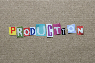 Production word with cutout letters on cardboard background