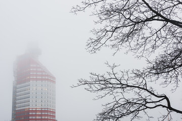 Mist covers Gothenburg harbour and a tall building during a foggy day
