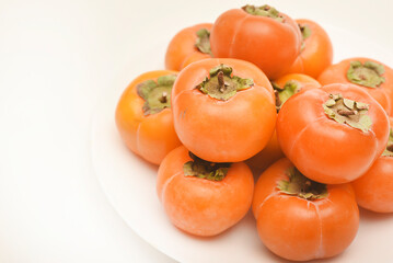 Orange persimmon fruits. Ripe persimmon on a plate.