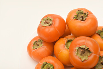 Orange persimmon fruits. Ripe persimmon on a plate.