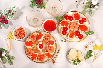French baguette with smoked salmon pate, red caviar, soft cheese and tomatoes, Christmas Eve concept, restaurant and cafe menu. Christmas and New Year dishes, a set of canapes for festive tables