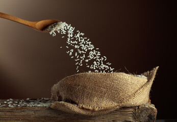Rice is poured into a burlap bag.