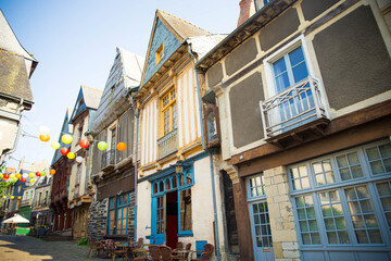 Rue d'en Bas, one of the medieval streets in old town center of Vitr&eacute;, Brittany, France, with half timbered houses and colorful lantern garlands..