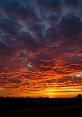 Obraz premium Intense, vibrant colors illuminate the horizon as dynamic, wispy clouds streak across the sky during a dramatic and inspiring magical sunset ,gold ,ethereal ,orange