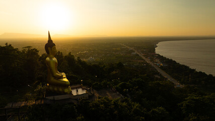Aerial view at sunset above the Mekong river in Laos revealing Pakse city golden giant buddha