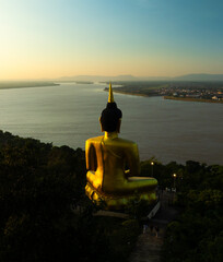 Aerial view at sunset above the Mekong river in Laos revealing Pakse city golden giant buddha