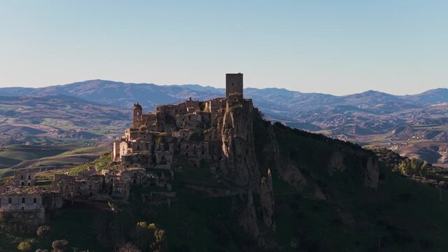Aerial view of the ancient Craco ruins perched atop a hill, blending with the rugged landscape in a mesmerizing display of history, Craco, Basilicata, Italy.