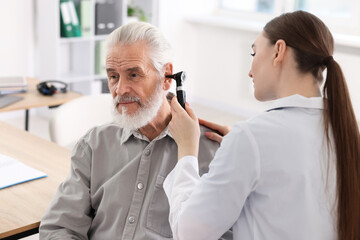 Obraz premium Hearing test. Doctor examining patient’s ear with otoscope in clinic