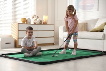 Obraz premium Cute little kids playing golf at home