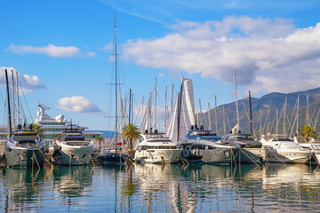 View of Porto Montenegro marina in Tivat city. Yachts and sailboats are reflected in water of Bay of Kotor. Montenegro