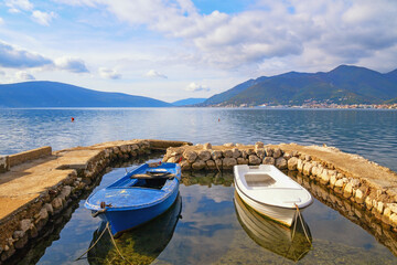 Beautiful autumn Mediterranean landscape. Montenegro, Adriatic Sea. View of Bay of Kotor near Tivat city, fishing boats in small harbour