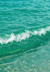 Fototapeta premium Sparkling, turquoise ocean water gently lapping the shore, representing relaxation, summer vacation, and tropical travel background, relaxation, holiday, exotic