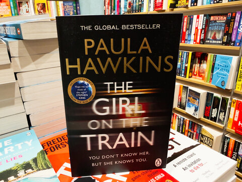The Girl on the Train by Paula Hawkins on display in a busy bookstore shelves