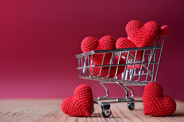 The red Heart shapes in shopping cart on red background , love concept for shopping on valentines day