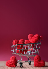 The red Heart shapes in shopping cart on red background , love concept for shopping on valentines day
