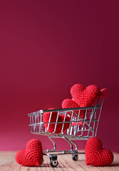 The red Heart shapes in shopping cart on red background , love concept for shopping on valentines day