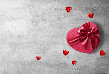 Red gift box with red ribbon on the grey background. Passion present. Happy Valentine Day.