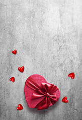 Red gift box with red ribbon on the grey background. Passion present. Happy Valentine Day.