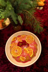 Christmas cookies on a plate. Festive cake decorated with dried oranges on a red velvet background
