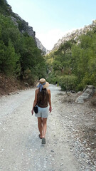 A woman walks along a mountain path in Goynuk Canyon, Turkey. Hiking the scenic road leading towards Goynuk Gorge.