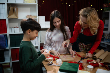 Family decorating christmas gifts with mother and children