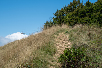 Un chemin menant à une croix sur un sommet