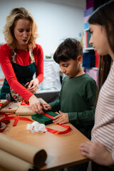 Fototapeta premium Family wrapping christmas gifts creating holiday presents