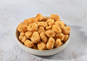 Crispy chicken popcorn in a ceramic bowl on white background. Fast food snack or appetizer. Close-up