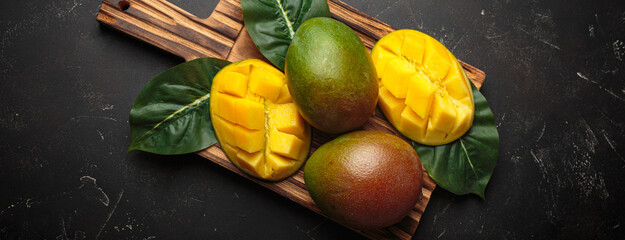 Fresh mango exotic fruit sliced whole cutting board dark background preparing