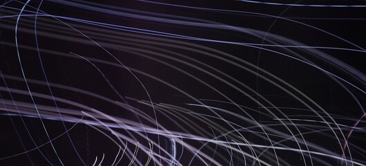 Abstract neon light trails. Long exposure. Dark motion blur background with copy space.