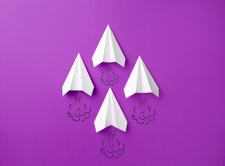 Paper planes with drawings of smoke on purple background