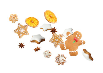 Christmas cookies, dried orange slices and anise stars flying in air on white background