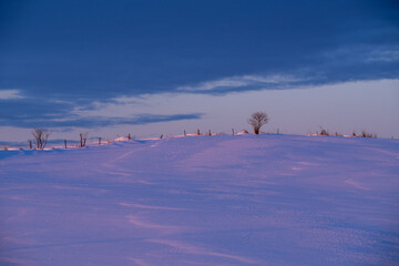Early morning light colors the winter hills