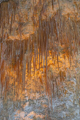 Backlit Needle Like Stalactites in a Cavern