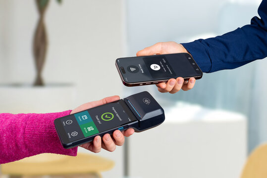 Smartphone and POS terminal completing a contactless payment, showing a modern merchant interface with approved transaction status during seamless NFC tap-to-pay interaction