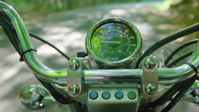 Close-up of motorbike handlebars on a scenic road