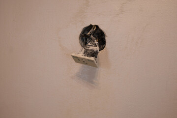 Wiring is visible in the wall where an electrical outlet has been removed, indicating a home renovation project underway