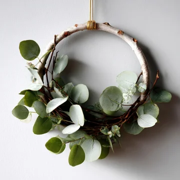 Minimal eucalyptus Christmas wreath on white wall