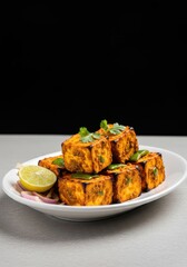 Appetizing closeup of spicy grilled paneer tikka cubes, marinated in delicious spices, presented beautifully on a white plate in a restaurant setting ,vegetarian, food, plate