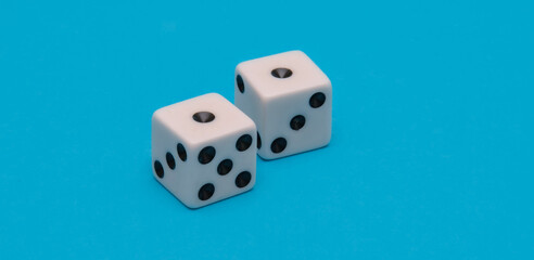 Close-up captures a white pair of dice resting on a vibrant blue surface. Symbolizing risk, luck and the excitement of chance. Perfect for gaming banners.