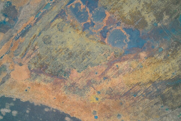 Aerial top down view of abstract colorful swamp texture with blue and orange hues. War zone wetland and artistic nature pattern background.