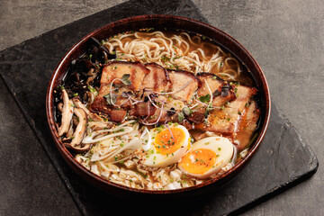 traditional japanese ramen bowl with pork belly, soft-boiled eggs and fresh vegetables
