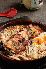 traditional japanese ramen bowl with pork belly, soft-boiled eggs and fresh vegetables