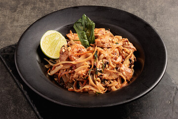 Pad Thai with Chicken and Shrimp Served in Black Bowl with Lime