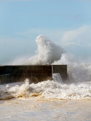 Stormy wave splash against sunny blue sky
