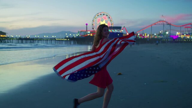 A girl enjoying Santa Monica beach at sunset with the pier in view